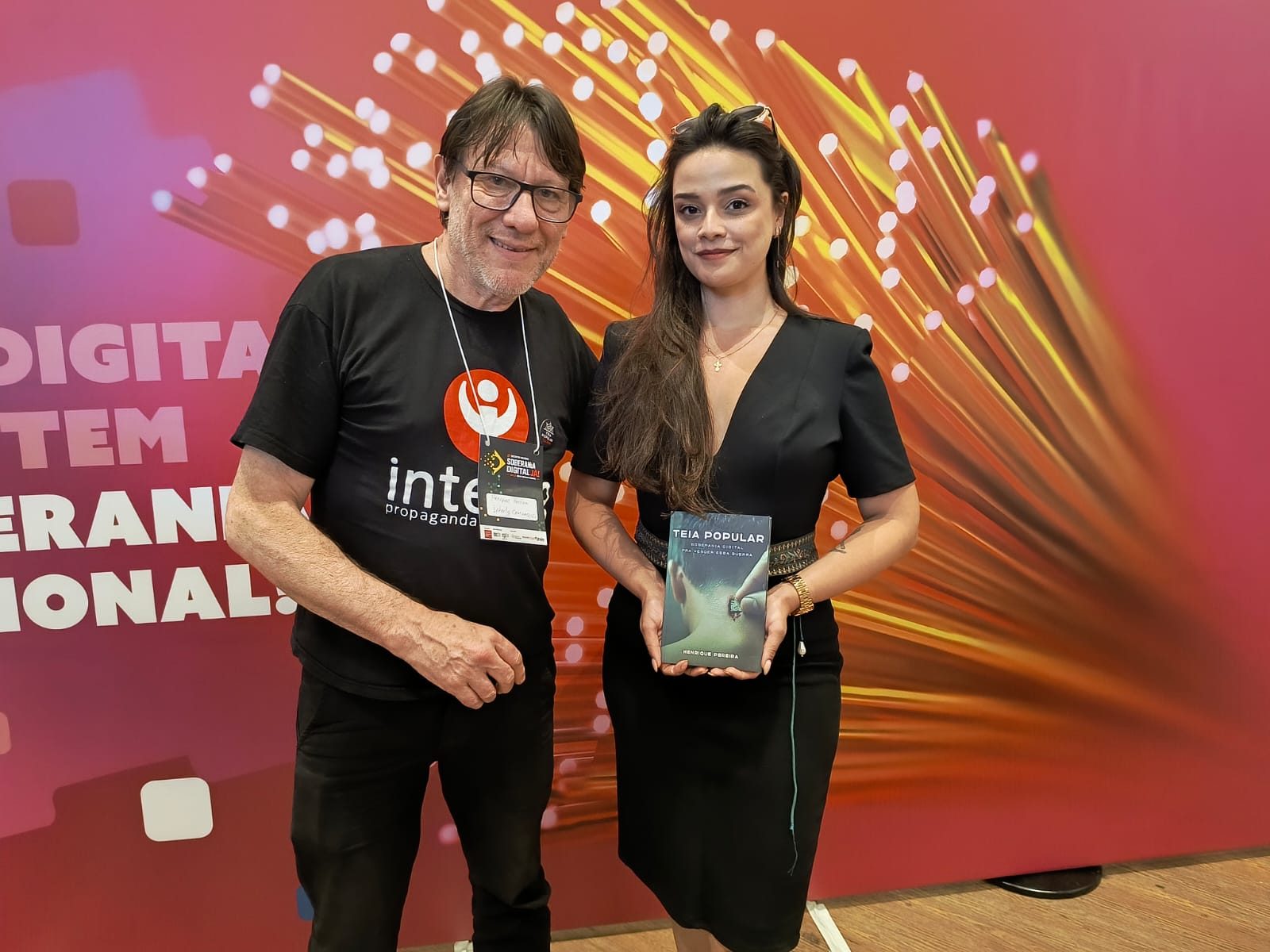Henrique Pereira com apoiadora e o livro em Brasília
